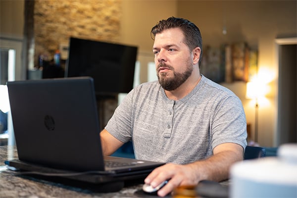 집에서 노트북을 사용하고 있는 토토사이트ONLINE 학생 Johnathan