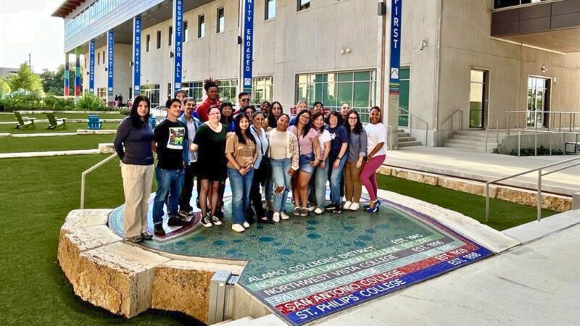 토토사이트 Access Building Courtyard에서 사진을 위해 포즈를 취하는 유학생 그룹