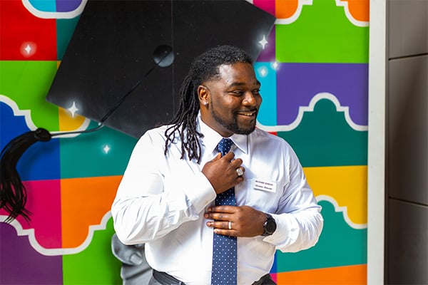 Richard Jordan은 토토사이트 Logos의 거리 그림 벽화 앞에서 포즈를 취합니다